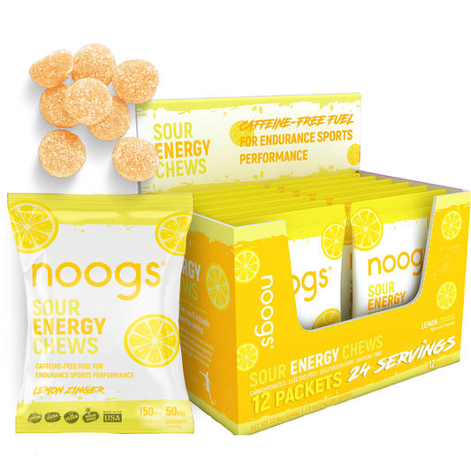 Box display of Noogs Sour Energy Chews in Lemon Zinger flavor with open packets and individual yellow chews visible.