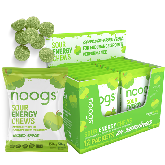 Box display of Noogs Sour Energy Chews in Wicked Apple flavor with open packets and green sour chews shown.